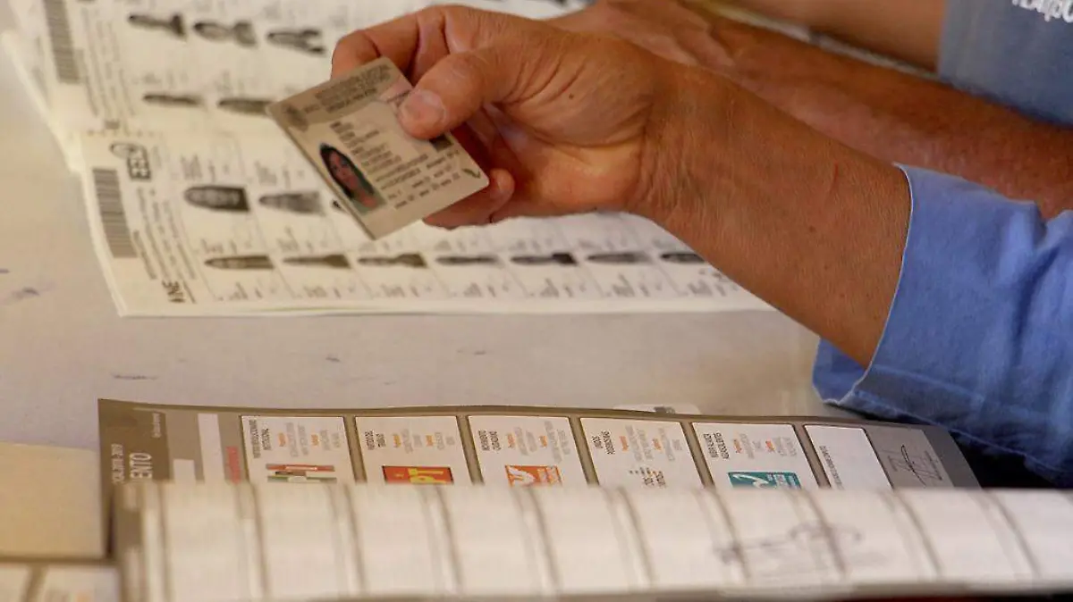 Persona sosteniendo credencial de lector frente a boletas